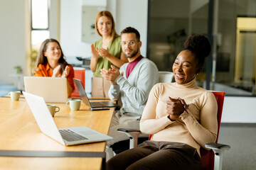 Cute Africam American woman with her young multiethnic startup team working in the modern office