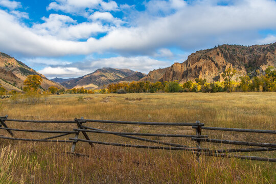Landscape of Pasture Land in an Absaroka Mountain Valley with Early Morning Light in Fall Color on a Cloudy Autum Day on the Road from Cody, Wyoming, USA to Yellowstone National Park