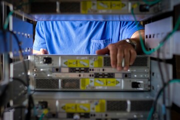 IT Engineer is pulling the server out out of the cabinet in the data center