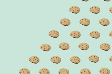 Pattern make of cookies on green background with copy space. Creative food concept.