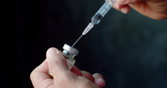 A syringe with medicine inside and aspirating medicine from another vial increases the amount of medicine to the desired dosage.Syringe with liquid being drawn into syringe.Testosterone.