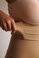 Plus size pretty model in correcting figure (body) stretch beige shorts.
Beautiful lady with big breasts and small waist wear underwear to correct her figure. Woman with long hair in bedroo in panties