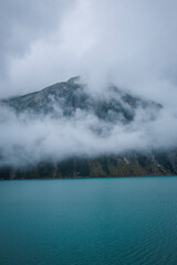 Fototapeta premium Nestled serenely amidst the rugged peaks of the majestic mountains, this pristine alpine lake captivates with its breathtaking beauty.