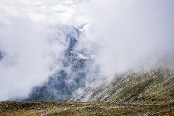 
The mountains, shrouded in a delicate veil of clouds, create an ethereal and mysterious landscape.