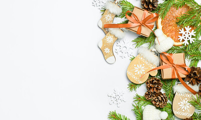 fir branches, gift boxes, pine cones and Christmas decorations on a light gray background, top view