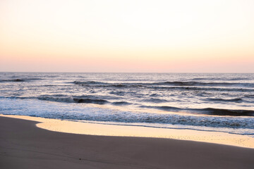 Fototapeta na wymiar Sunrise over the sea. Pastel shades. Beautiful landscape. Sandy beach of the ocean. Sunset sky.