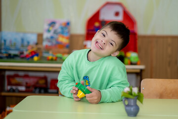 A child with Down syndrome plays in kindergarten