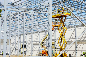 Steel frame structure assembly using self propelled scissor lift platform and articulating boom lift - obrazy, fototapety, plakaty