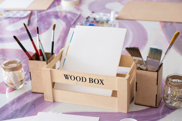 Painting supplies on a table. Watercolors, brushes, paintbrushes, tassel, white blank sheet of paper. Art master class