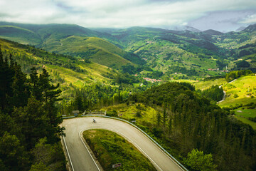 Man riding bicycle down hill filmed from drone DJI. Nansa Valley in Cantabria, Spain.