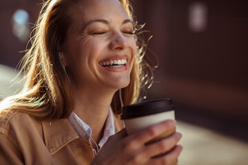 Woman relishing her coffee with a joyful expression - obrazy, fototapety, plakaty