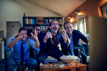 Enthusiastic friends react to a pivotal moment in a sports game on TV