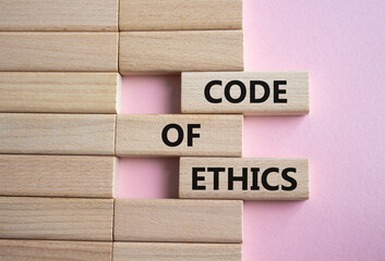 Code of ethics symbol. Concept words Code of ethics on wooden blocks. Beautiful pink background....