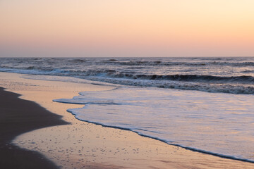 Sunrise over the sea. Pastel shades. Beautiful landscape. Sandy beach of the ocean. Sunset sky.