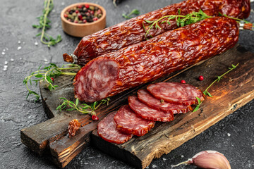 Traditional slice salami sausage with spices on a wooden board. banner, menu, recipe place for...