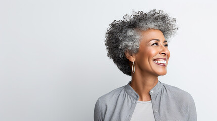 Obraz premium Beautiful aged mature woman with short gray hair and happy smile on a white background with copy space