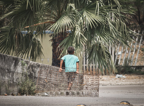 ni&ntilde;o arrastrando fierros y resortes de un colchon 