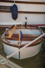 Stylish classic wooden boat with flag in the bow.