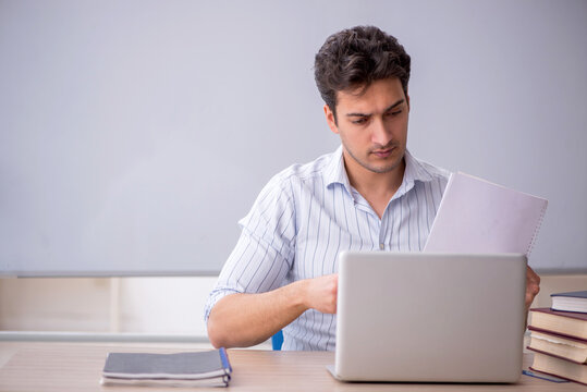 Young male teacher in front of white board