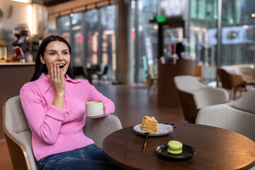 A girl in a pink shirt sitting in a cafe and feeling positive