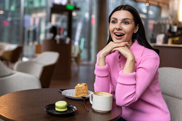 A girl in a pink shirt sitting in a cafe and feeling positive