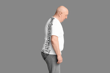 Senior man with poor posture on grey background
