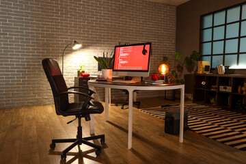 Programmer's workplace with computer in interior of dark office