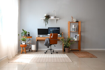 Interior of light office with programmer's workplace and houseplants