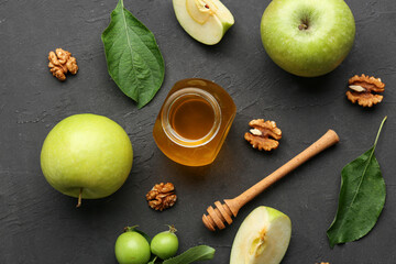 Jar of honey with walnut and apples for Rosh Hashanah celebration (Jewish New Year) on black background