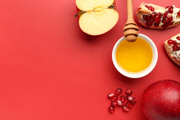 Fototapeta na wymiar Jar of honey with pomegranate and apples for Rosh Hashanah celebration (Jewish New Year) on red background