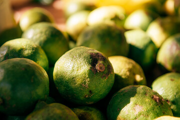 Ripe green limes in close-up, on a counter or shelf, in a store or hypermarket