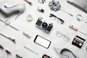 Composition with cosmetics, accessories and gadgets on light background