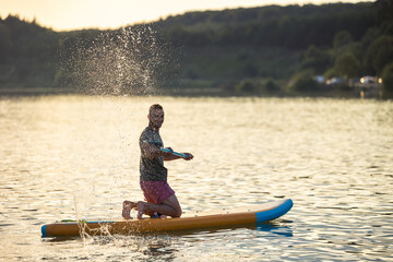 Man on the supboard on the middle of the lake.