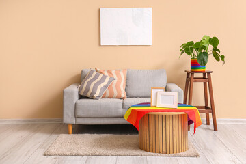 Interior of living room with sofa and LGBT flag on table