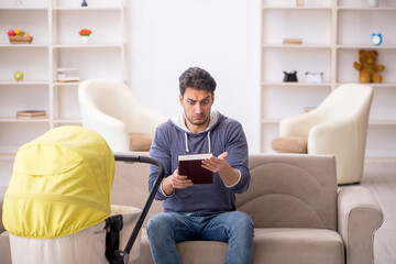 Young man looking after newborn at home