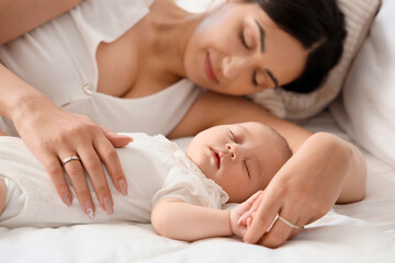 Mother with her little cute baby sleeping in bedroom at home