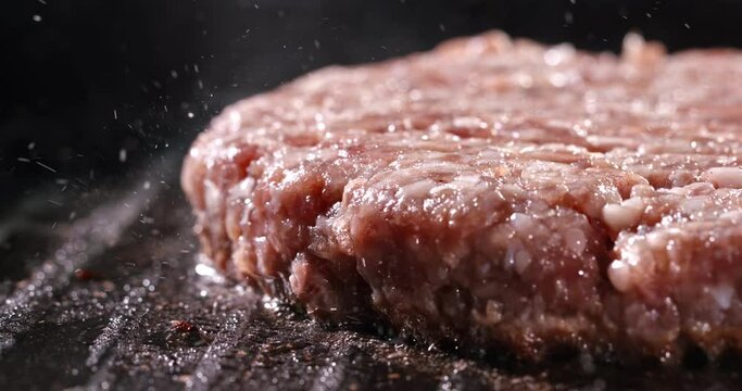 Beef cutlet for halal burger fried in frying pan. Cinematic advertising burger cooking. Ultimate burger with irresistible pan-fried cutlets. Cooking beef patty for burger, meat roasted at kitchen.