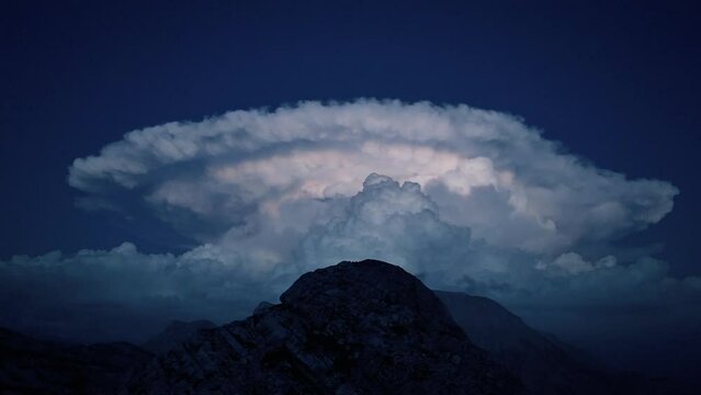 avvicinamento alla nube temporalesca con fulmini sulle cime delle montagne