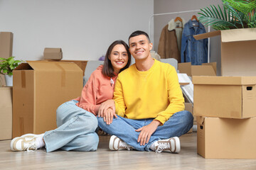 Fototapeta na wymiar Happy young couple sitting in room on moving day