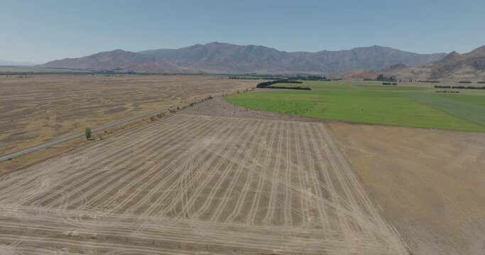 Aerial Shot Of Agricultural Field Against Sky On Sunny Day, Drone Flying Over Landscape - Otago, New Zealand