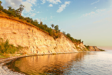 Dawn on the Volga. Beautiful cliffs by the river in the morning rays of the rising sun at golden...