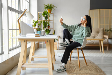 Young Asian woman working with mobile phone at home office