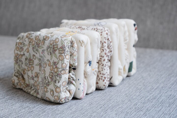 stack of clean baby clothes with a pattern on grey background. Neatly folded clothes