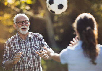 Nurse and senior man playing football in park - 670738258