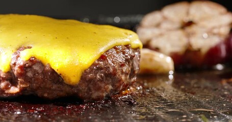 Macro shot of frying beef halal cutlets with melted cheese on top. Cinematic advertisement burger cooking. Perfect beef cutlet fried in a pan with rosemary sprigs and garlic. Traditional meal.