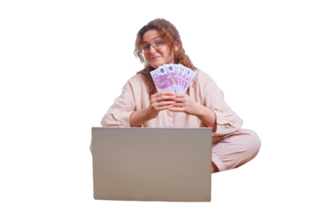 Happy woman holds money in hands while sitting by the laptop, isolated on a white background. The woman received a salary in euros at remote work during isolation due to coronavirus