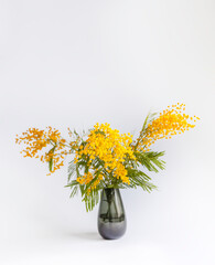 Yellow mimosa flowers in a vase.