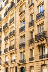 Fototapeta na wymiar Façade of a typical and elegant residential building in Passy quarter, in Paris, France, with wrought iron railings and balconies 