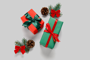 Gift boxes with Christmas tree branches and cones on white background