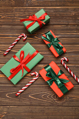 Christmas gift boxes with candy canes on wooden background
